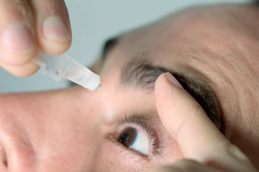 Man using eye drops